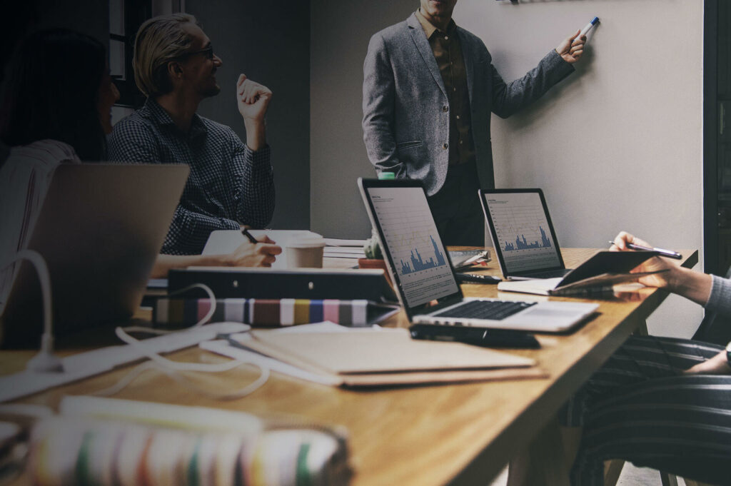 Business and Event Insurance web page background image - Picture of employees in office during presentation.